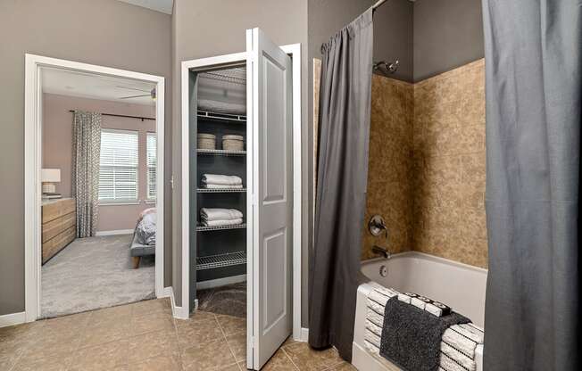 interior model bathroom with a tub,shower, and linen storage closet
