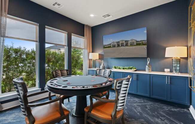 a gaming room with a table and chairs and windows