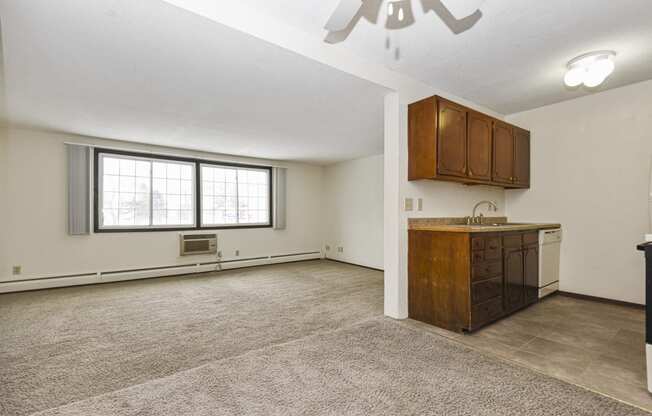 a  living room with a kitchen and a window. Fridley, MN Georgetown on the River Apartments