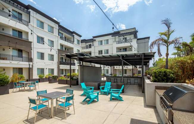 A patio with a table and chairs is surrounded by apartment buildings.