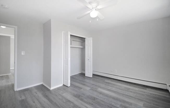 a living room with white walls and a ceiling fan