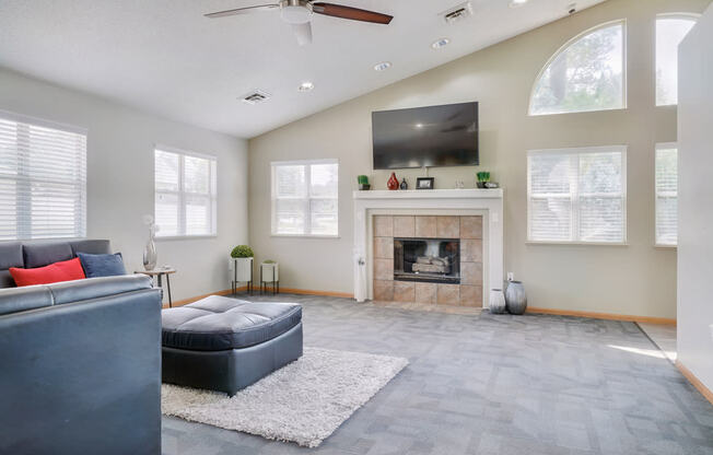 Lounge space with sectional couch and fireplace with TV mounted above it