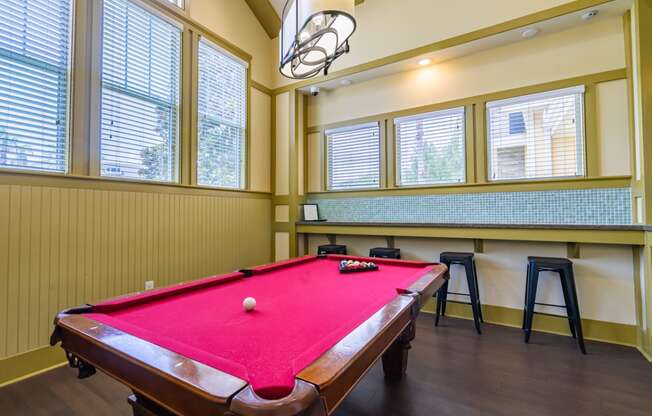 a games room with a pool table and bar