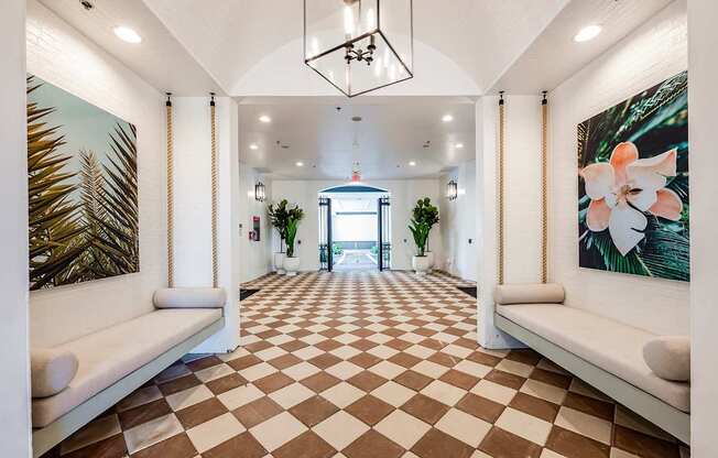 A long hallway with a checkered floor and white walls.