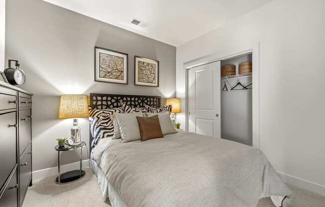 A bedroom with a large bed and a nightstand with a lamp.