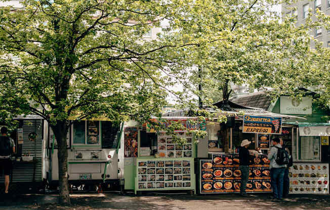 a row of food trucks on the side of a street