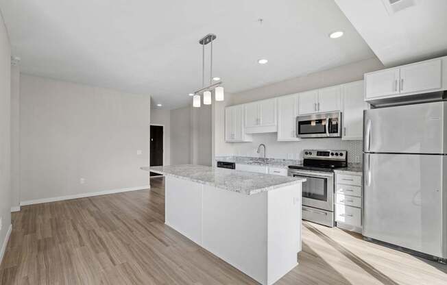 A modern kitchen with stainless steel appliances and a marble island.