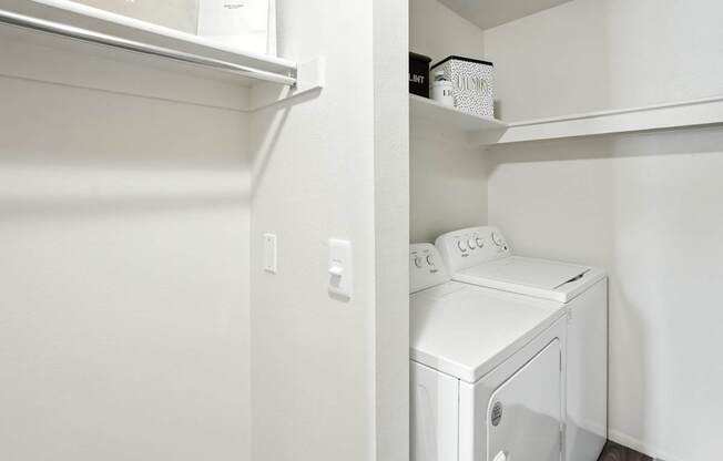 A white washing machine is in a small laundry room.