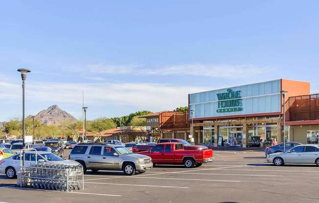 a parking lot filled with cars in front of a shopping center