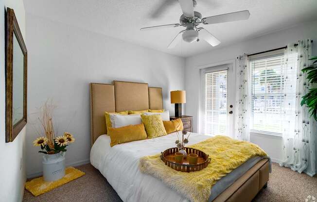 A bedroom with a white bed and yellow pillows.