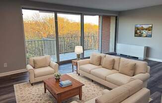 A living room with a sofa, armchair, and coffee table.