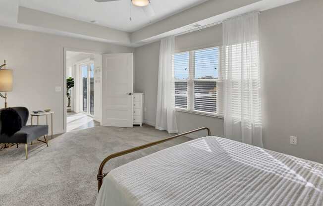 a bedroom with a bed and a window with white blinds