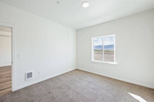 a bedroom with white walls and a window at Gateway Apartments, East Wenatchee , WA 98802