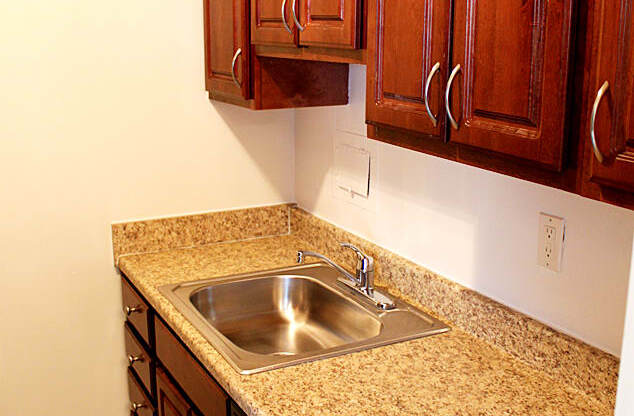 A kitchen with a granite counter top and wooden cabinets Integrity Realty, Cleveland, OH