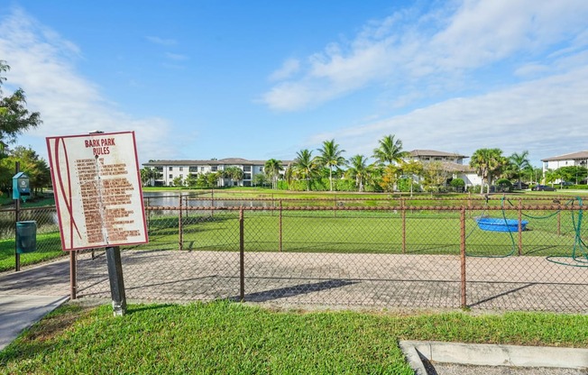 A sign in a park provides information about the park's rules and regulations.