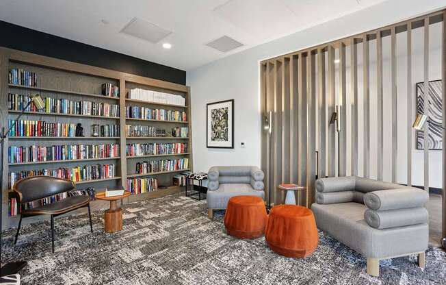 A living room with a bookshelf, a chair, a table, and a rug.