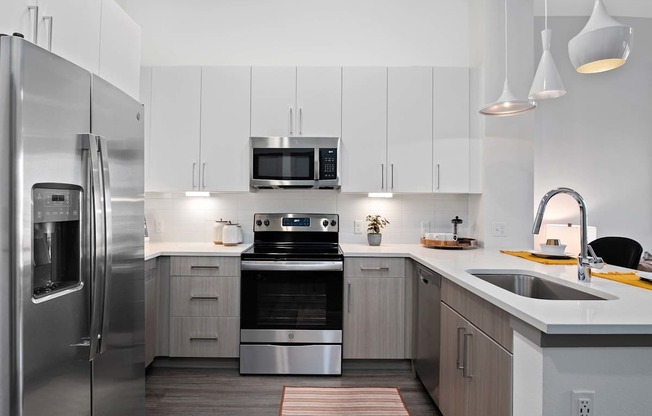 A modern kitchen with a stainless steel refrigerator and a stove top oven.