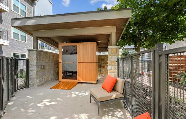 A patio with a couch and a table with a pillow on it.