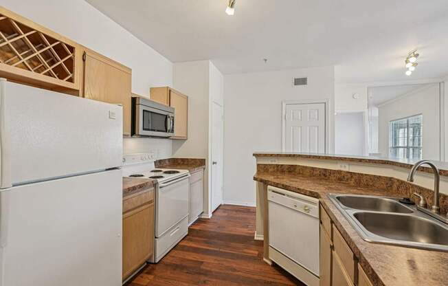 A kitchen with white appliances and wooden cabinets.