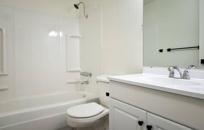 a white bathroom with a sink toilet and bath tub