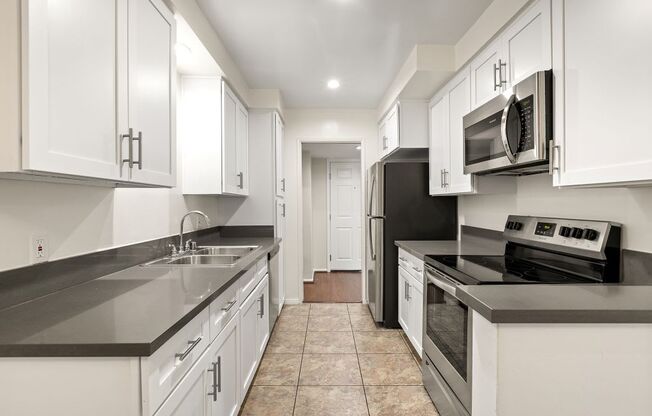 a modern kitchen with white cabinets and black counter tops