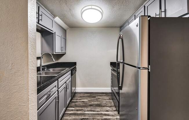 a kitchen with stainless steel appliances and a wooden floor