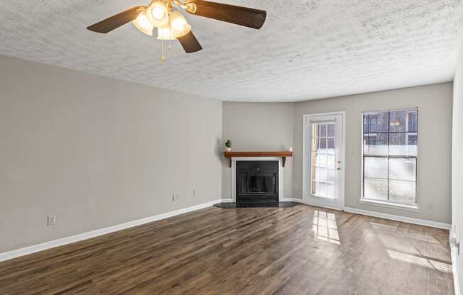A room with a fireplace and a ceiling fan.