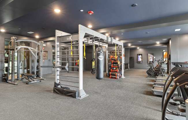 A gym with a variety of equipment including treadmills, weights, and exercise machines.