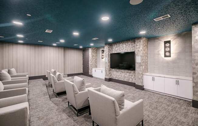 A room with a row of chairs and a television on the wall.