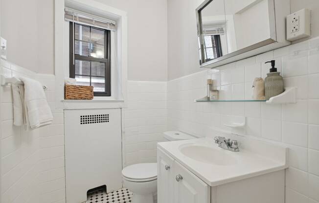 a white bathroom with a black and white checkered floor