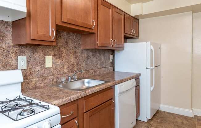 a kitchen with a sink and a stove and a refrigerator at Hamilton Manor Apartments, Maryland, 20782