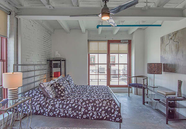 Steelcote Lofts bedroom with polished concrete floors, high ceilings and ceiling fan at Steelcote Square, St. Louis