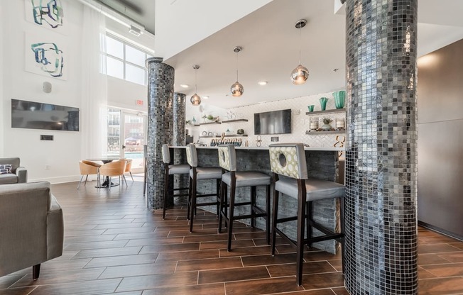 a kitchen with a bar and stools in front of a large window