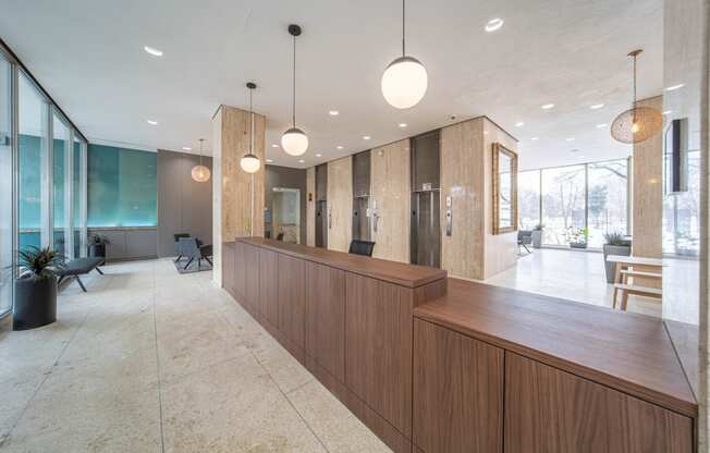 a large lobby with a wooden reception desk and glass walls