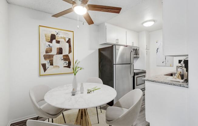 a kitchen and dining room with a white table and chairs