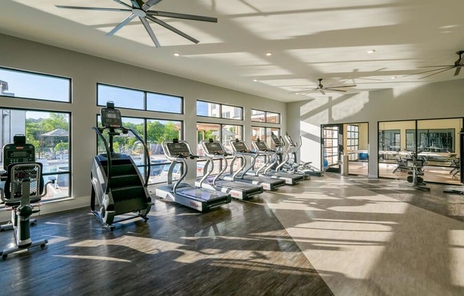 Gym with big windows and cardio equipment at The Eddy at Riverview, Georgia, 30126