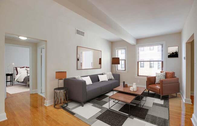 A living room with a grey couch, a brown chair, and a coffee table.