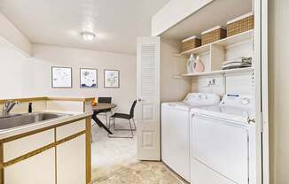 A kitchen with a washer and dryer at South Bridge Apartments in Fort Wayne, IN