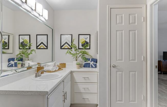 a white bathroom with a sink and a mirror