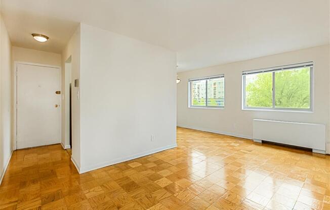 vacant living area with large windows, hardwood flooring and view of front entrance at chillum place apartments in lamond riggs washington dc