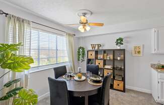 a dining room with a table and chairs and a ceiling fan