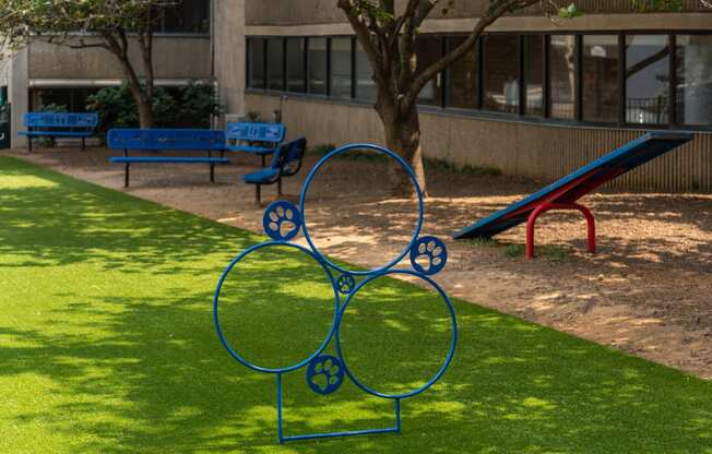 a blue sculpture in the shape of a bike in a park