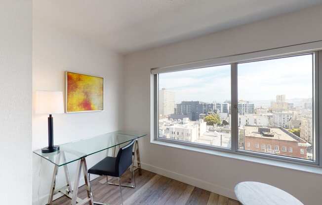 a room with a large window and a glass desk with a chair