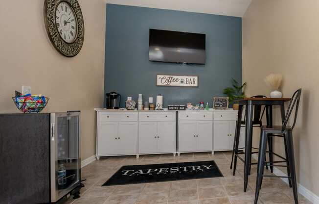 a living room with a bar with chairs and a television