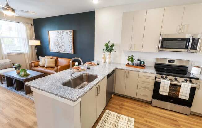 an open kitchen and living room with a granite counter top