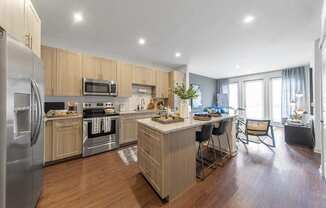 a kitchen with a center island and a stainless steel refrigerator