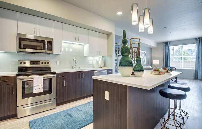 A modern kitchen with a large island and stainless steel appliances.
