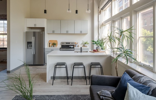 a kitchen with a large window and a white island with a white countertop at The 22 Apartments, Missouri, 63103