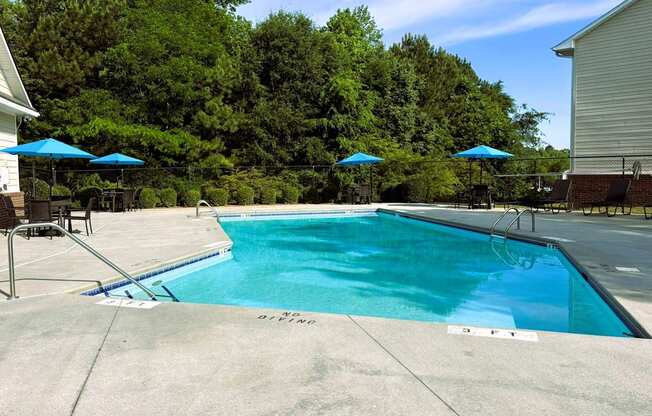 A swimming pool surrounded by trees and a house.