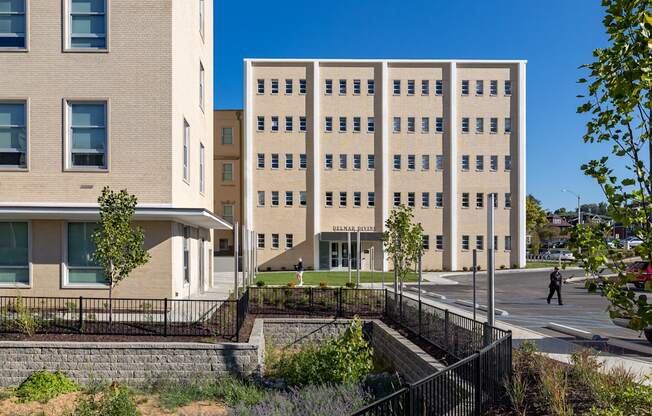 A black fence separates a grassy area from a building.